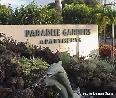 Paradise Gardens - Custom cut letters with faux-bronze patine finish. Stud mounted on wall.