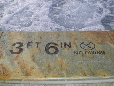 Four Seasons Pool - Pool depth and no dive marker, blasted in place on pink quartz.